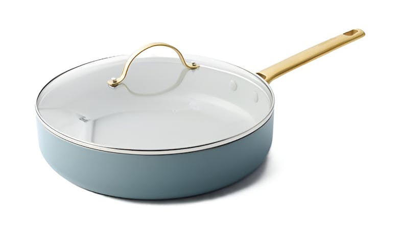 Angled view of a blue GreenPan Padova 28cm sauté pan with a glass lid and gold handle Angled view of a blue GreenPan Padova 28cm sauté pan with a glass lid and gold handle