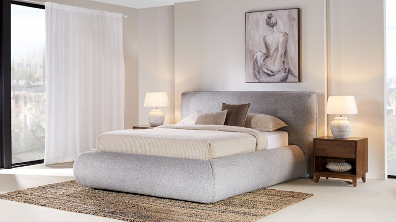 A stylish Leon Queen Bed Frame featuring a rounded, textured grey fabric base and matching headboard A stylish Leon Queen Bed Frame featuring a rounded, textured grey fabric base and matching headboard