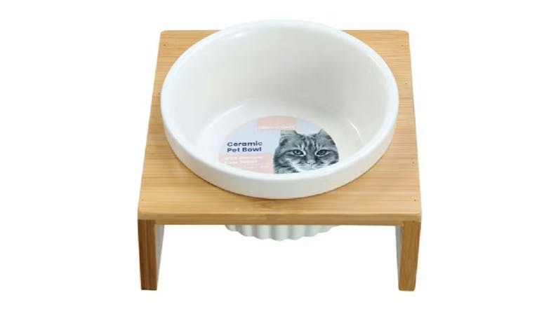 White ceramic pet bowl on a wooden stand with a printed label White ceramic pet bowl on a wooden stand with a printed label