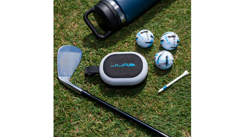 JLab Pop Party speaker shown with golf accessories in a sunny outdoor setting JLab Pop Party speaker shown with golf accessories in a sunny outdoor setting