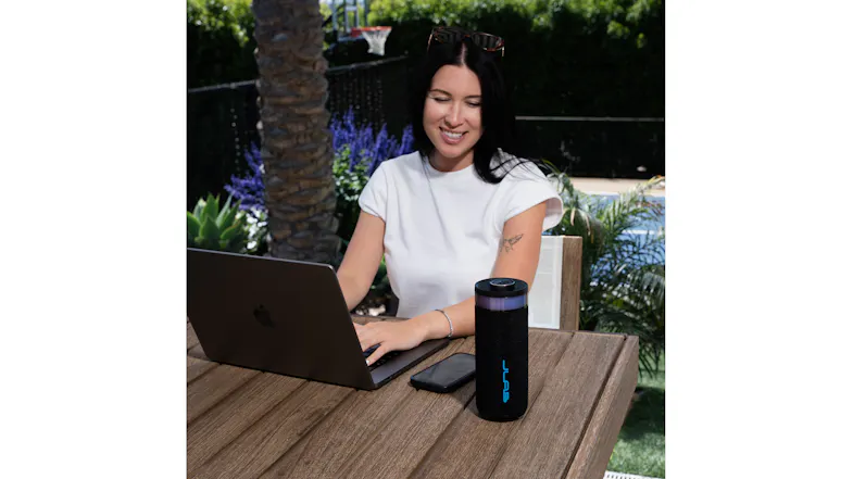 JLab Go Party speaker with integrated light ring used at a desk during an outdoor work session JLab Go Party speaker with integrated light ring used at a desk during an outdoor work session