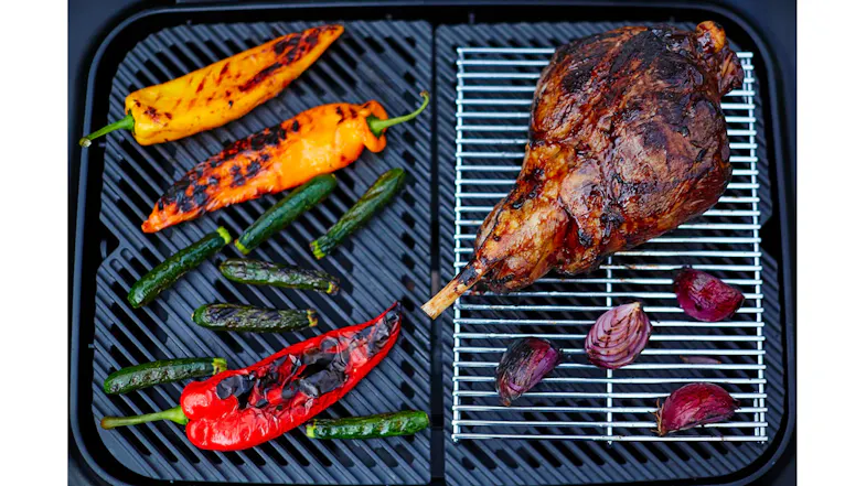 Top‑down view of the dual cooking zones showing grilled vegetables on one side and roasted meat Top‑down view of the dual cooking zones showing grilled vegetables on one side and roasted meat
