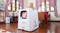 A Hello Kitty-themed cat litter box in an indoor setting with a cat on top A Hello Kitty-themed cat litter box in an indoor setting with a cat on top