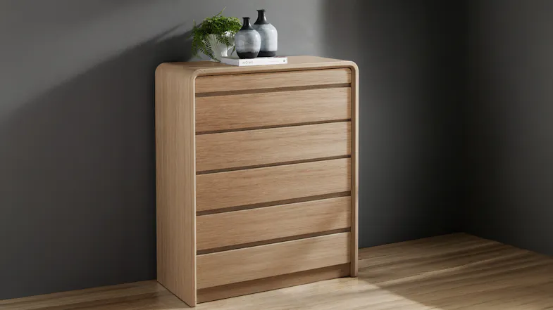 Angled profile of the Arc 6 Drawer Tallboy showing its sleek, curved wooden silhouette Angled profile of the Arc 6 Drawer Tallboy showing its sleek, curved wooden silhouette