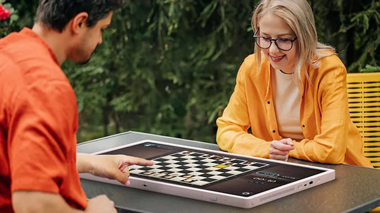 A view of two adults playing chess using the TV A view of two adults playing chess using the TV