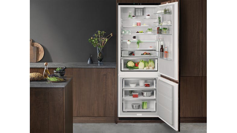 Fully stocked refrigerator integrated into dark wood modern kitchen cabinetry Fully stocked refrigerator integrated into dark wood modern kitchen cabinetry