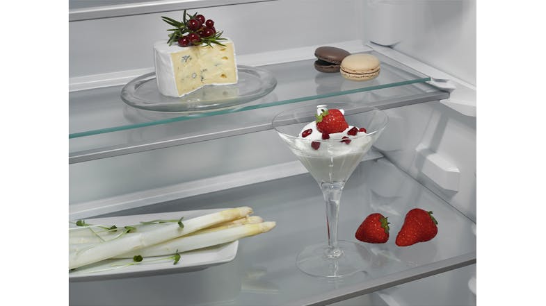 Close-up of clear glass shelves holding desserts and fresh berries Close-up of clear glass shelves holding desserts and fresh berries