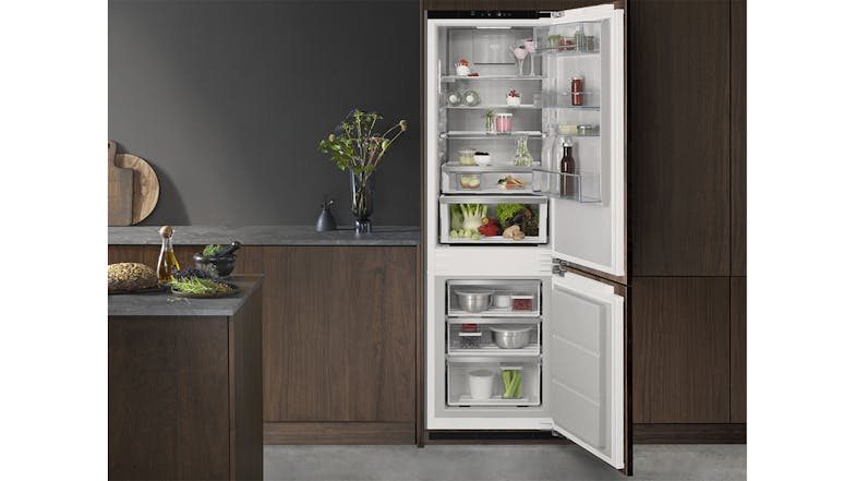 Fully stocked refrigerator integrated into dark wood modern kitchen cabinetry Fully stocked refrigerator integrated into dark wood modern kitchen cabinetry