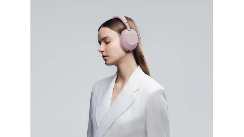 Side view of a woman wearing Sony Over-Ear Headphones in Sand finish Side view of a woman wearing Sony Over-Ear Headphones in Sand finish