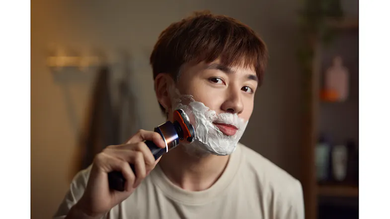 A front view of a man shaving his beard using the Philips Shaver A front view of a man shaving his beard using the Philips Shaver