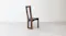 Side view of the wooden dining chair showing the tall open-back design, gently curved backrest, and cushioned seat Side view of the wooden dining chair showing the tall open-back design, gently curved backrest, and cushioned seat