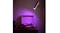 Floor lamp casting purple light onto an open record player on a wooden cabinet in a dimly lit room Floor lamp casting purple light onto an open record player on a wooden cabinet in a dimly lit room