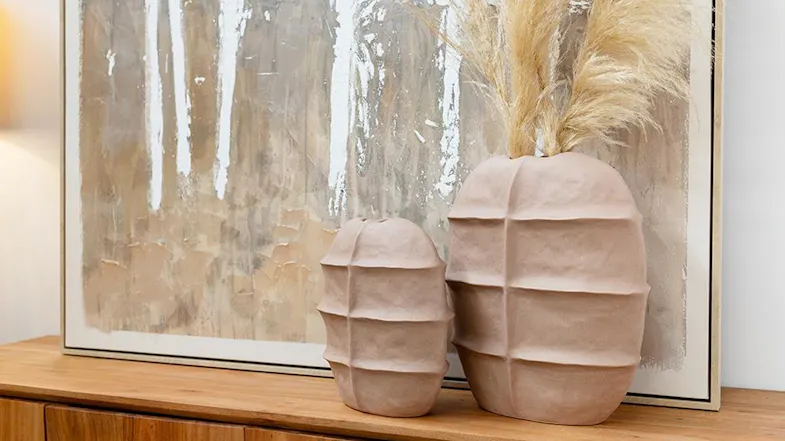 Two rounded, textured vases on a wooden sideboard Two rounded, textured vases on a wooden sideboard