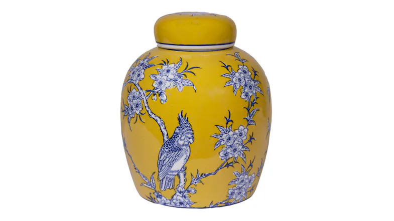 A rounded yellow ceramic jar with a fitted lid, decorated with blue flowering branches and a perched bird design A rounded yellow ceramic jar with a fitted lid, decorated with blue flowering branches and a perched bird design