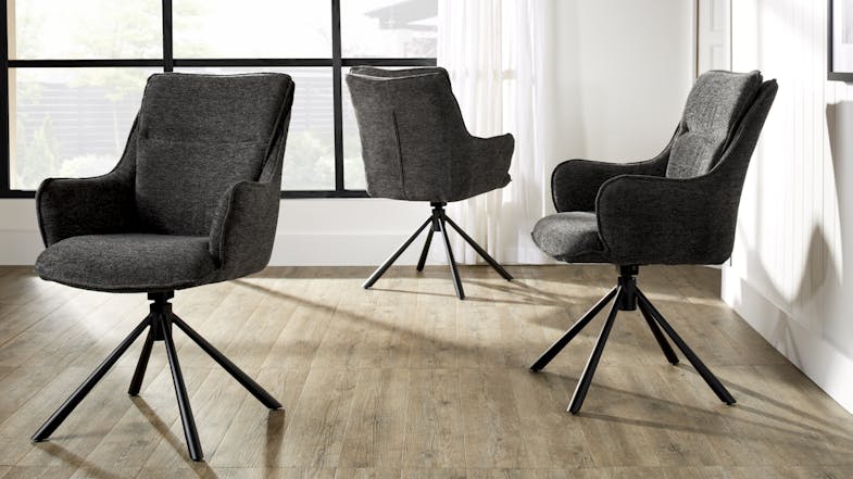 A set of three charcoal upholstered bar stools arranged in a bright room with wood flooring A set of three charcoal upholstered bar stools arranged in a bright room with wood flooring
