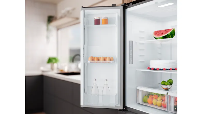 The right fridge door open, showing shelves holding beverages and eggs next to the main fridge interior The right fridge door open, showing shelves holding beverages and eggs next to the main fridge interior