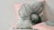 Angled view of a square pink pillow with a grey poppy graphic Angled view of a square pink pillow with a grey poppy graphic