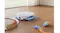 White circular vacuum navigating around toys on a wooden floor White circular vacuum navigating around toys on a wooden floor