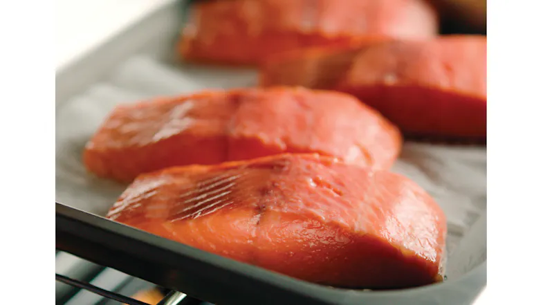 Close‑up of salmon fillets on a baking tray inside the oven, showing even steam‑assisted cooking Close‑up of salmon fillets on a baking tray inside the oven, showing even steam‑assisted cooking