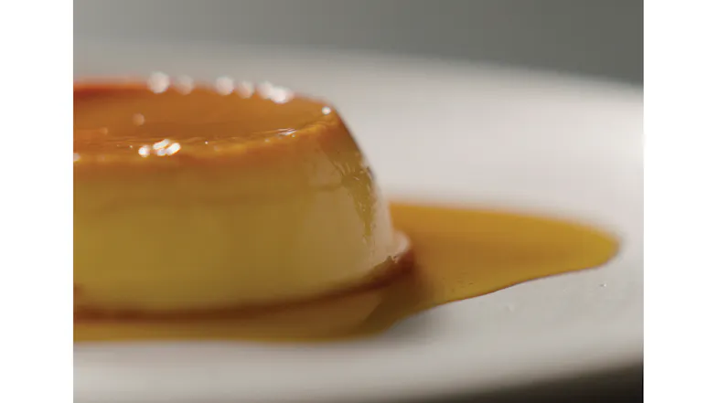 Close‑up of a custard dessert topped with caramel sauce on a white plate Close‑up of a custard dessert topped with caramel sauce on a white plate