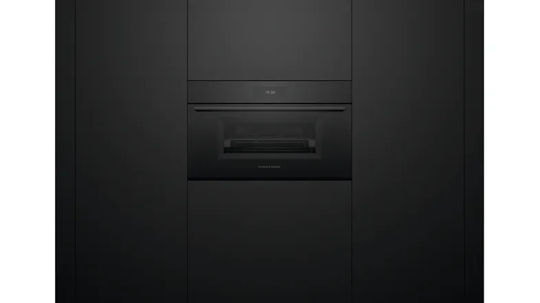 Oven installed flush within matte black cabinetry with the door closed and the interior faintly visible Oven installed flush within matte black cabinetry with the door closed and the interior faintly visible