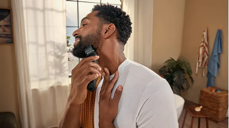 A person trimming the beard underside in a modern room A person trimming the beard underside in a modern room
