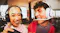 Two people laughing while wearing gaming headsets in a living room Two people laughing while wearing gaming headsets in a living room