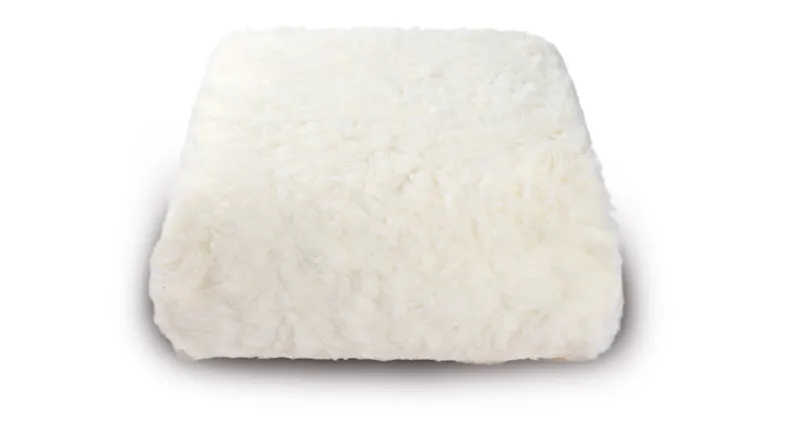 A fluffy white throw with a faux fur look A fluffy white throw with a faux fur look