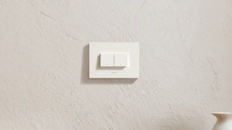 A minimalist interior featuring a white two-button smart light switch mounted on a textured wall above decor A minimalist interior featuring a white two-button smart light switch mounted on a textured wall above decor