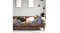 A person relaxing on a couch supported by the grey wedge pillow set A person relaxing on a couch supported by the grey wedge pillow set