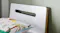 Close-up view of a white wooden headboard with a cutout handle Close-up view of a white wooden headboard with a cutout handle