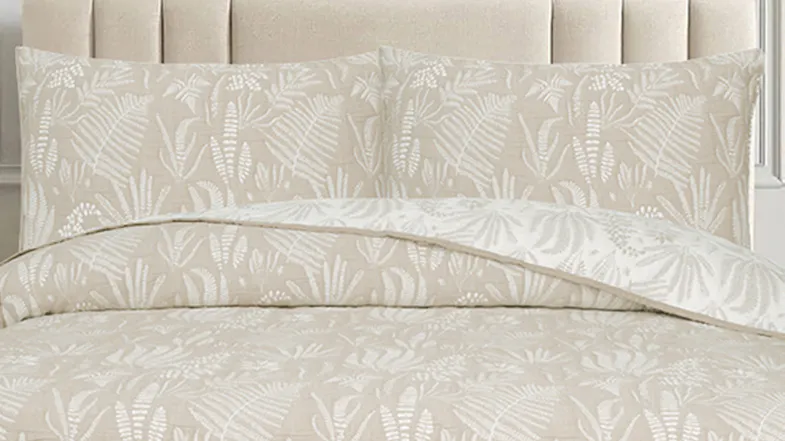 Close‑up view of the pillows and coverlet, featuring the quilted botanical design against the natural background Close‑up view of the pillows and coverlet, featuring the quilted botanical design against the natural background