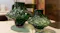 Two organic-shaped emerald green glass vases on a marble tabletop Two organic-shaped emerald green glass vases on a marble tabletop