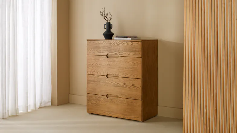 Resonance 4 Drawer Tallboy in a light oak finish standing against a neutral wall Resonance 4 Drawer Tallboy in a light oak finish standing against a neutral wall