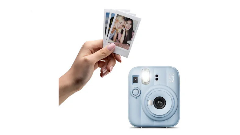 Hand holding small printed photos above a film camera Hand holding small printed photos above a film camera