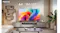 A Hisense TV sits on a grey console table in a bright, modern living room A Hisense TV sits on a grey console table in a bright, modern living room