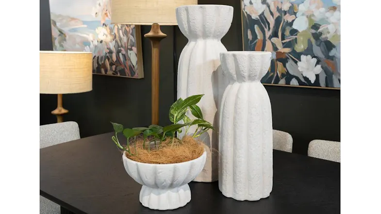 Two tall white textured stoneware vases displayed on a dark table in a decorated room, next to a white fluted bowl planter Two tall white textured stoneware vases displayed on a dark table in a decorated room, next to a white fluted bowl planter