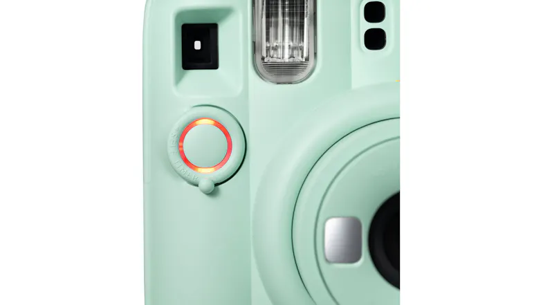 Close-up view of a film camera's shutter button with a glowing red Close-up view of a film camera's shutter button with a glowing red