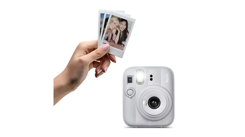 Hand holding small printed photos above a film camera Hand holding small printed photos above a film camera
