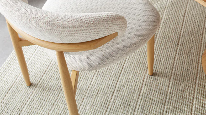 Close-up of the back and seat of a Ryder dining chair, highlighting the textured fabric and wood frame Close-up of the back and seat of a Ryder dining chair, highlighting the textured fabric and wood frame