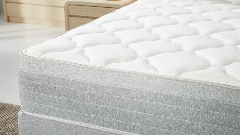 Side close‑up of the mattress edge, focusing on the soft quilted top layer and textured fabric Side close‑up of the mattress edge, focusing on the soft quilted top layer and textured fabric