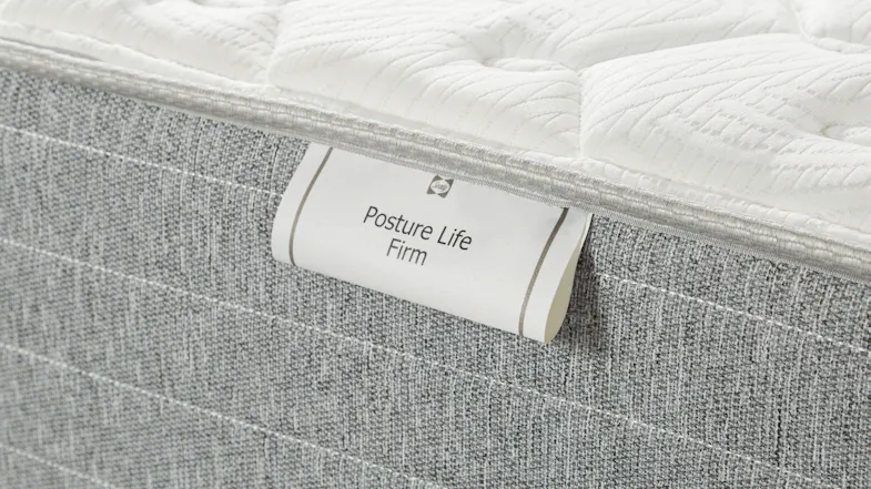 Detailed close‑up of the side label reading “Posture Life Firm” showing the mattress fabric texture Detailed close‑up of the side label reading “Posture Life Firm” showing the mattress fabric texture