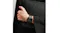 Apple Watch worn on a wrist with the black link bracelet, paired with a dark outfit Apple Watch worn on a wrist with the black link bracelet, paired with a dark outfit