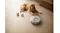 The unit navigates a wooden floor near a dog and a food bowl The unit navigates a wooden floor near a dog and a food bowl