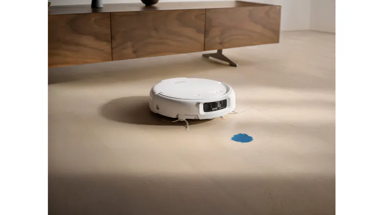 The white vacuum approaches a blue liquid spill on a light floor The white vacuum approaches a blue liquid spill on a light floor