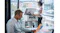 A woman is placing a large architectural flyer onto the glass scanner bed A woman is placing a large architectural flyer onto the glass scanner bed