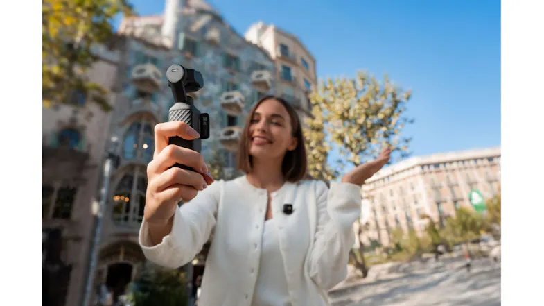 A woman recording a vlog with the compact gimbal in a city plaza A woman recording a vlog with the compact gimbal in a city plaza