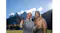 A smiling couple posing for a selfie video in a sunny alpine meadow A smiling couple posing for a selfie video in a sunny alpine meadow