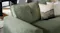 Close‑up of the Botany sofa’s green fabric upholstery showing the weave, padded armrest, and back cushion Close‑up of the Botany sofa’s green fabric upholstery showing the weave, padded armrest, and back cushion