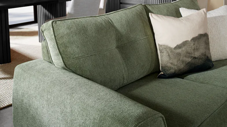 Close‑up of the Botany sofa’s green fabric upholstery showing the weave, padded armrest, and back cushion Close‑up of the Botany sofa’s green fabric upholstery showing the weave, padded armrest, and back cushion